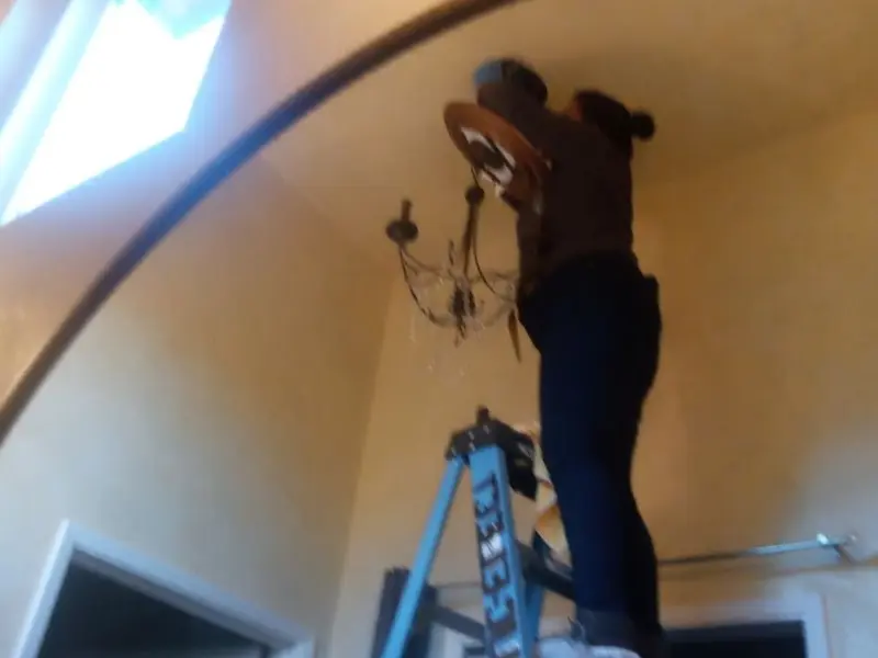 Electrician installing a chandelier in a Lake California residence